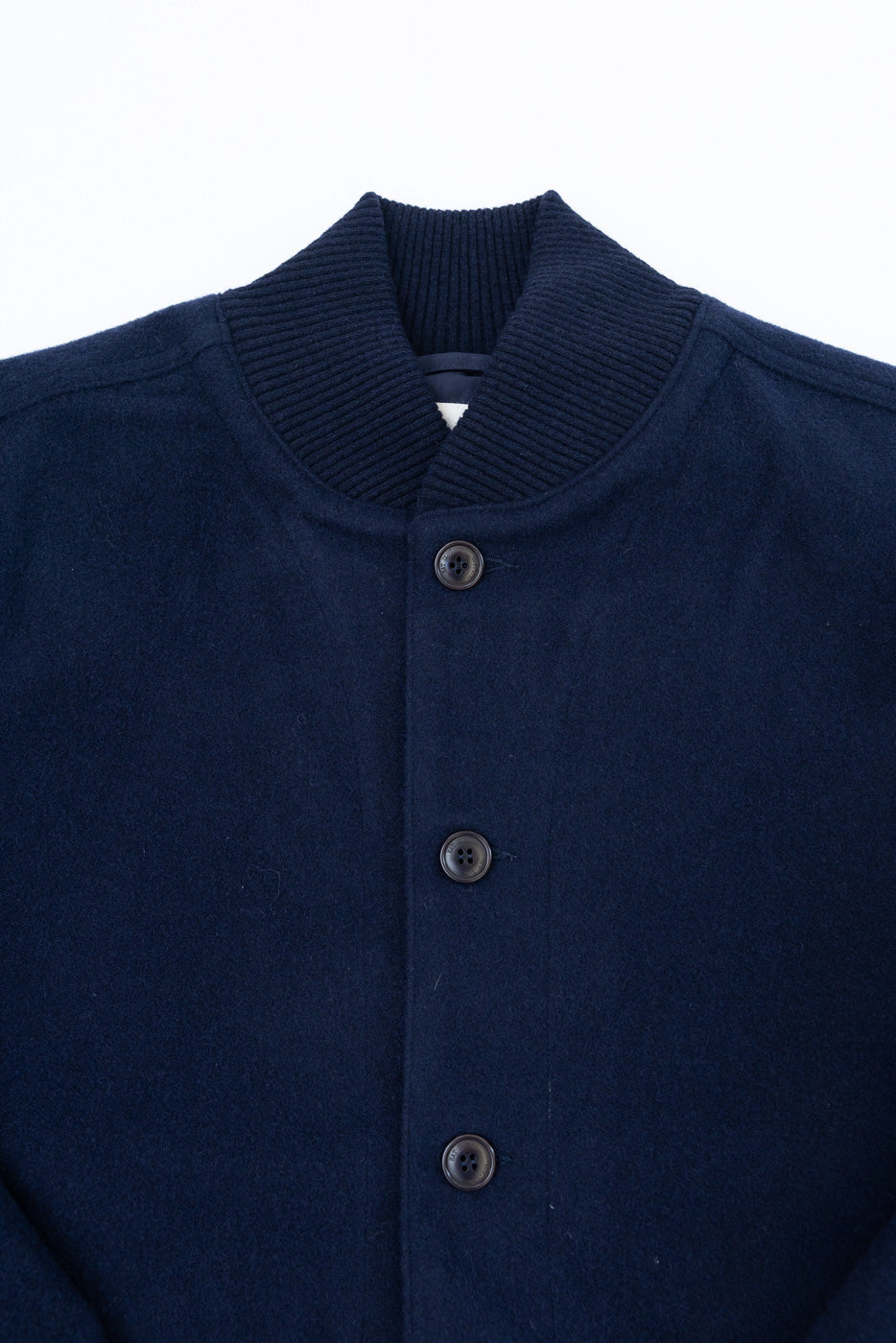 Close-up front view of a navy blue bomber jacket showing the ribbed collar and buttons.