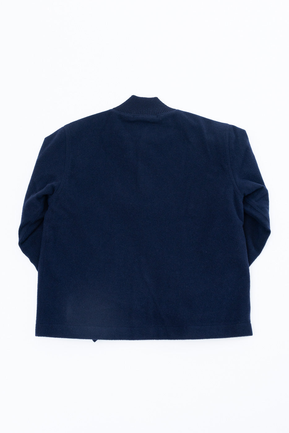 Flat lay showing the back of a navy blue fleece jacket with a ribbed collar.