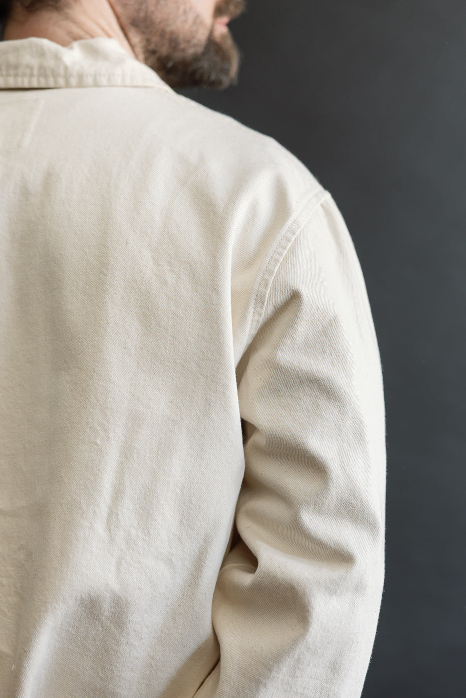 Close-up of men's ecru jacket back shoulder, male model 5'9