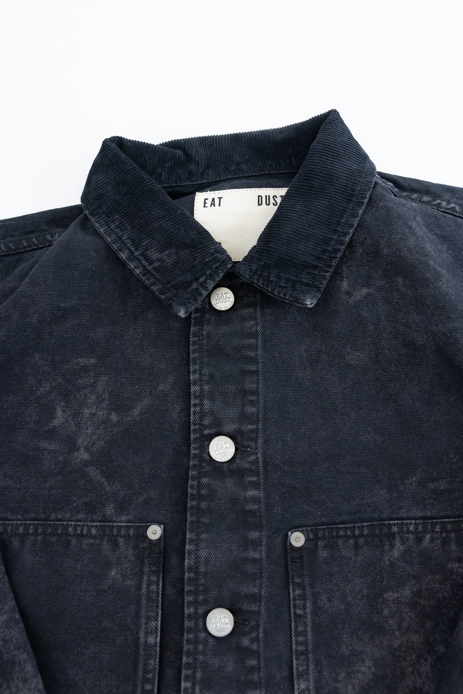 Close-up front view of canvas jacket, showing collar, front buttons, and chest pockets.
