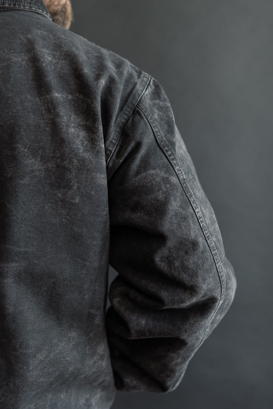 Close-up of back and sleeve, canvas Arizona jacket in asphalt on male model, 5'9