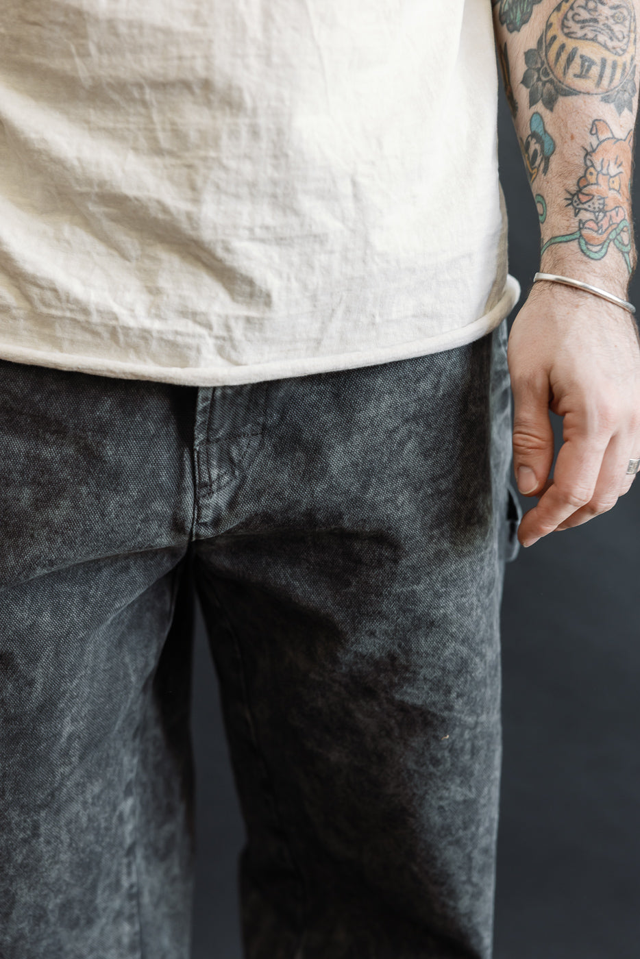 Close-up front view of men's asphalt canvas chino pants on male model, 5'9