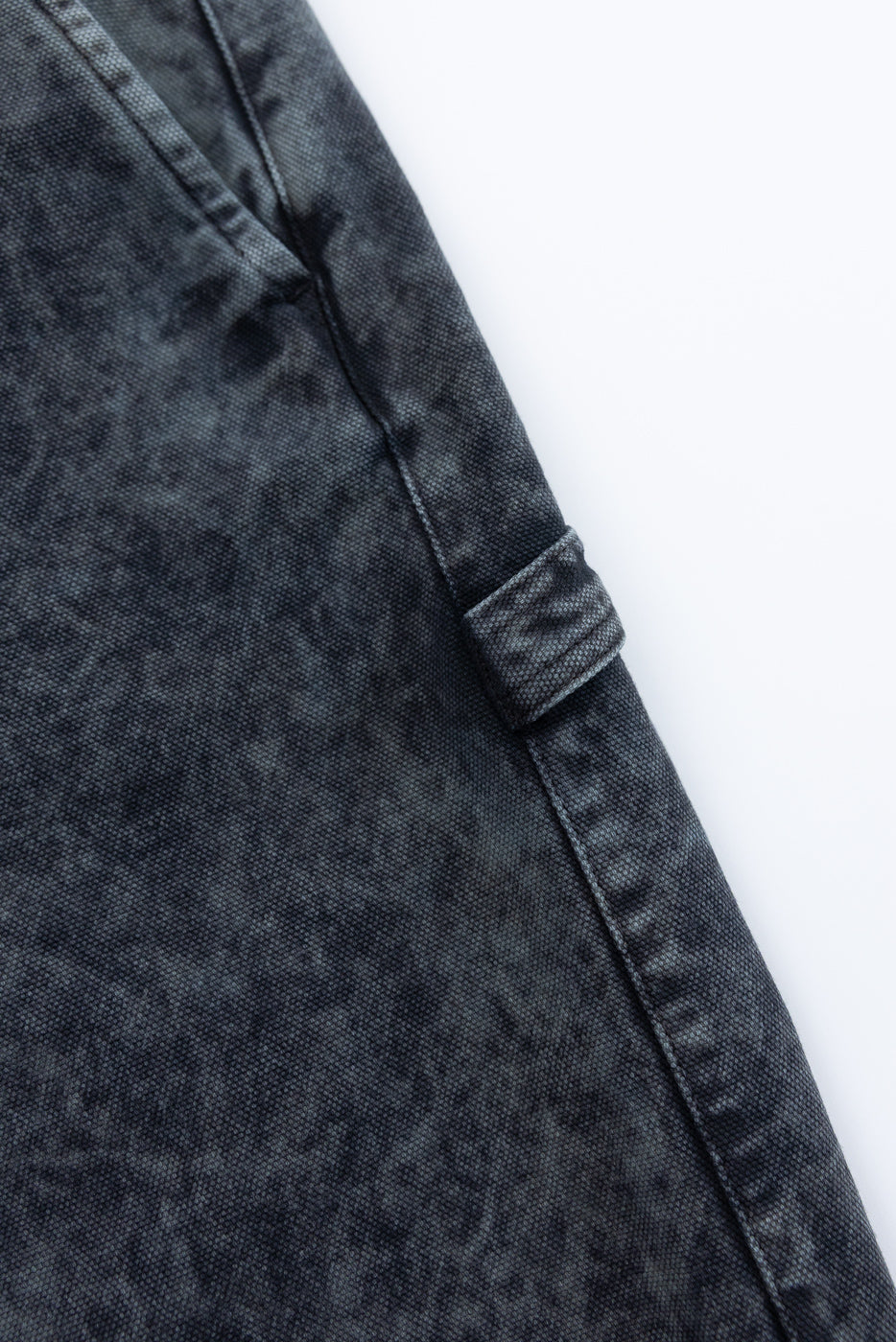 Close-up of men's asphalt canvas chino pants, showing side pocket and belt loop details.