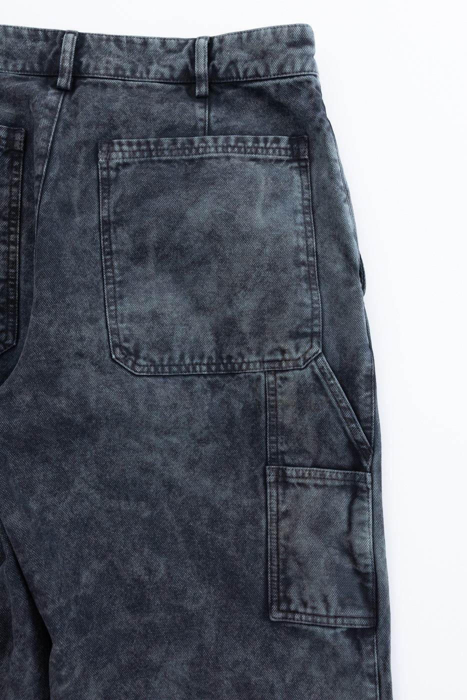 Close-up of rear and side pockets on right back side of men's canvas pants, showing textured fabric details.