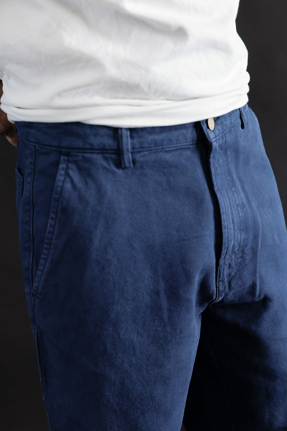 Close-up front view of indigo blue canvas chino pants on male model, 5'9