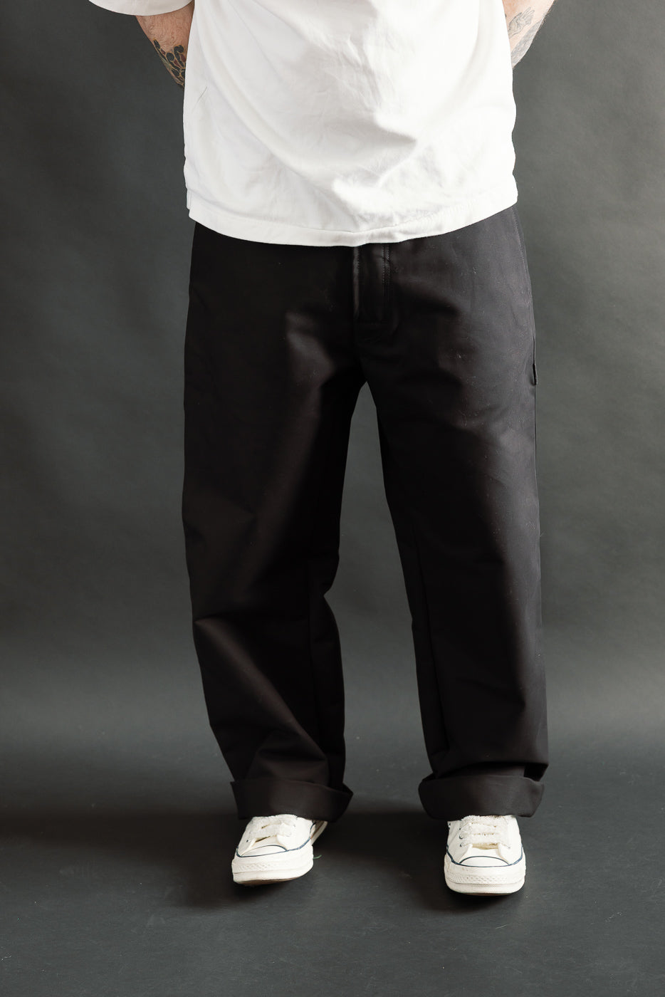Front view cropped image of male model 5'9, 165lbs athletic build wearing black Oakland Chino cotton pants, contemporary casual style at Dant.