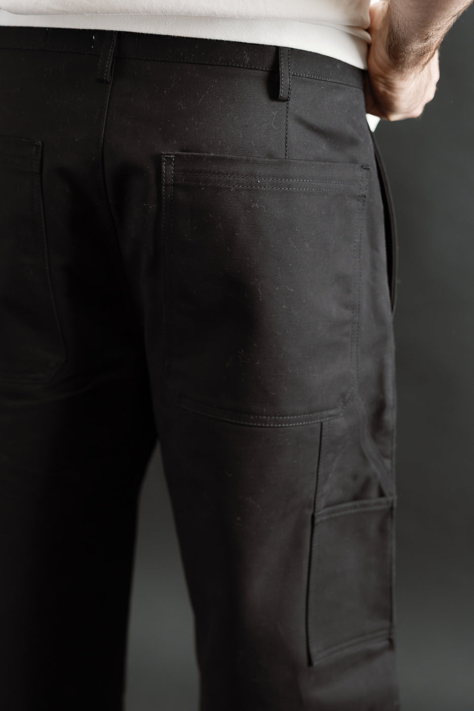Close-up of back and side of black cotton chino pants on male model, 5'9