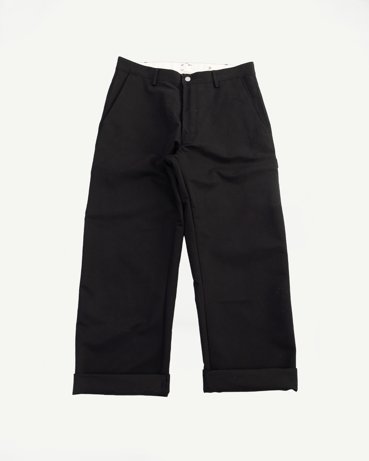 Flat lay, front view of black Oakland chino pants with cuffed hems and side pockets, Dant apparel