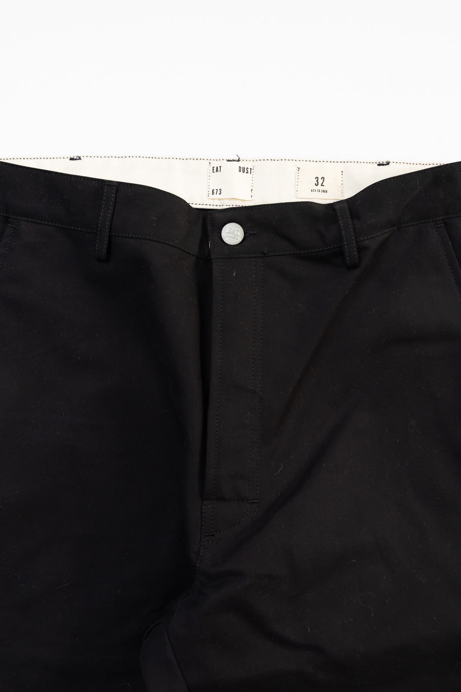 Close-up of Eat Dust Oakland Chino front waist, black cotton, button detail, size tag visible