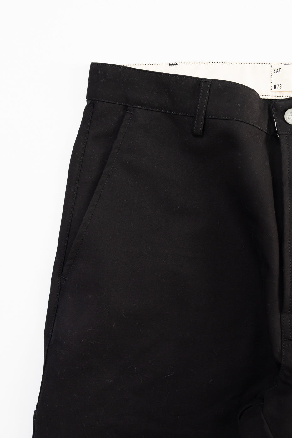 Close-up of front left side, black cotton Oakland Chino with patch, waistband and pocket details