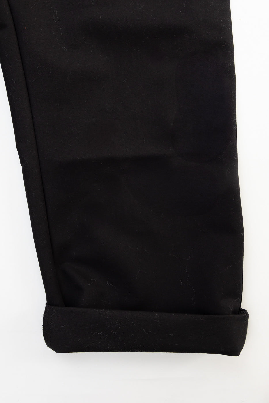 Close-up of black cotton Oakland chino leg, front lower cuff detail, contemporary casual style