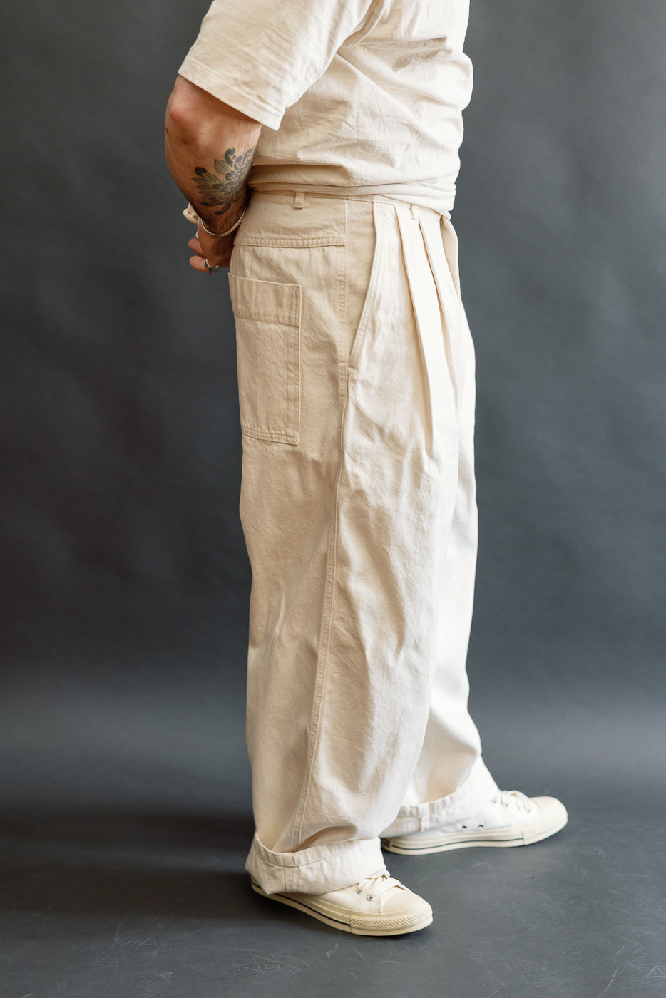 Side view close-up of cream canvas pants on male model 5'9