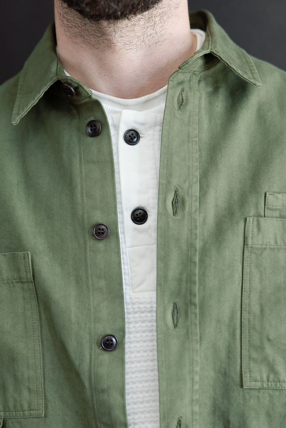 Close-up front view of olive green button-down shirt on male model, 5'9