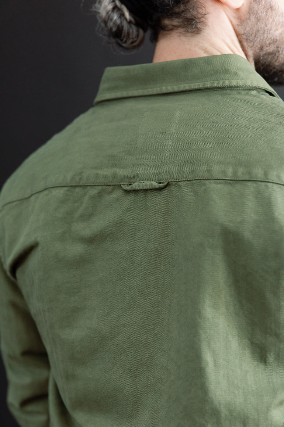 Close-up back view of an olive green shirt on a male model, 5'9