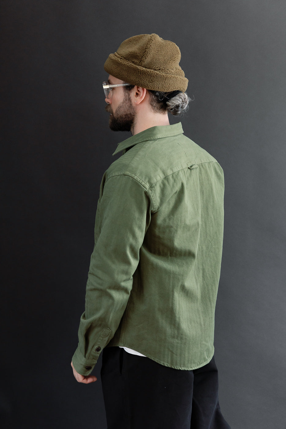 Back view of an olive green button-down shirt on a male model, 5'9
