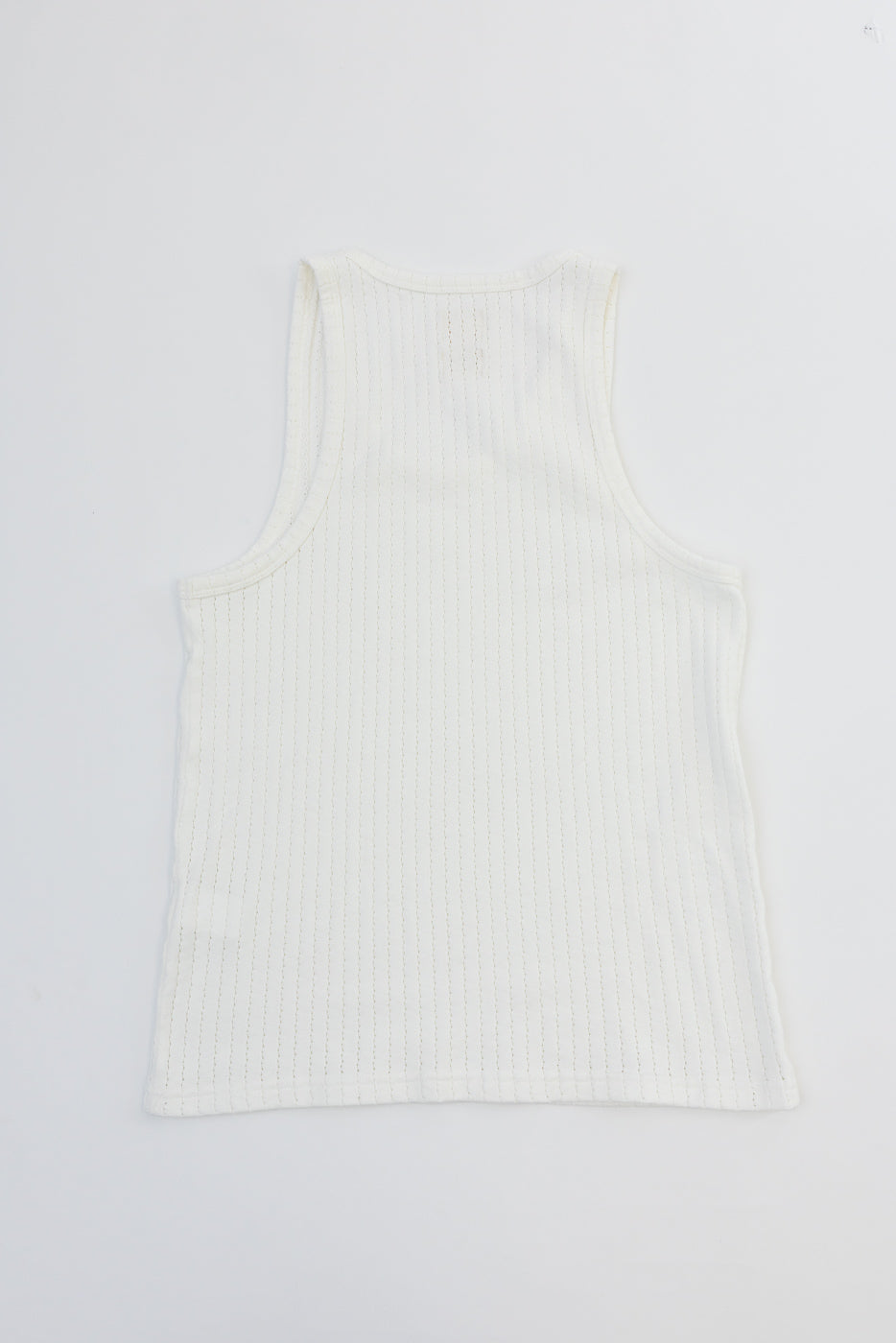 Flat lay of white mesh cotton tank top, back side, showing ribbed texture and hem detail.