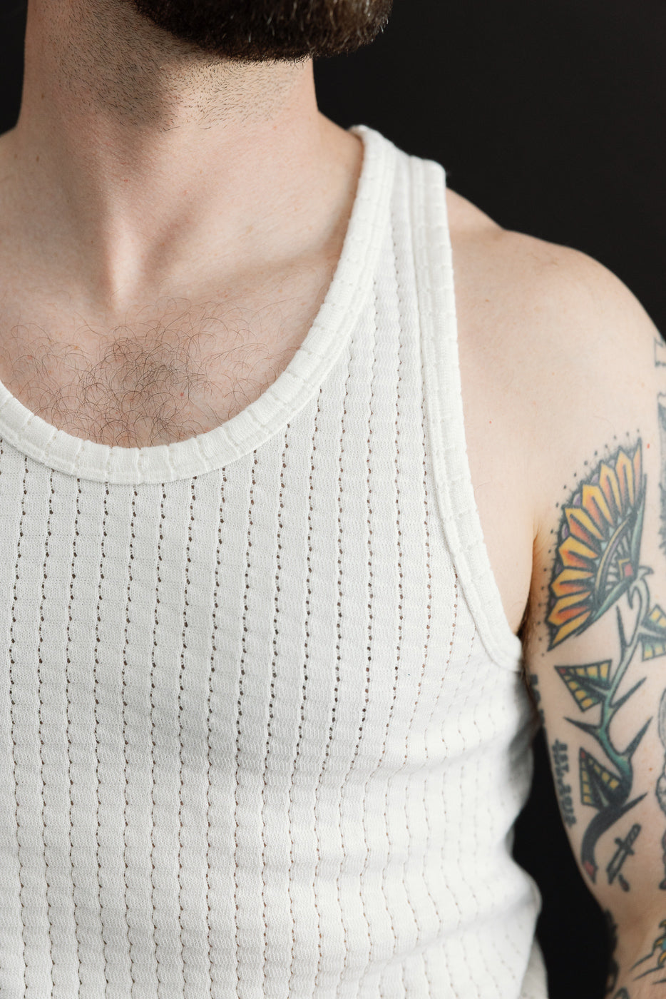 Close-up front of white mesh cotton tank top on male model, 5'9