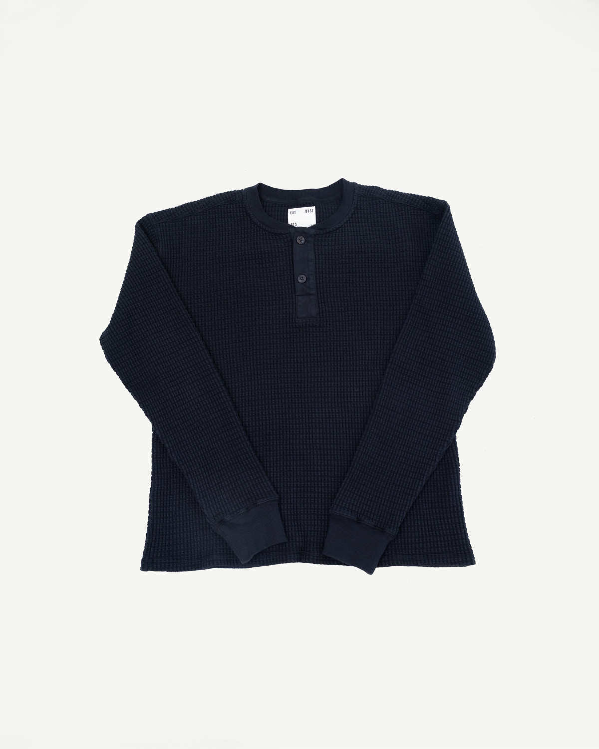 Front view flat lay of a navy blue waffle knit long sleeve thermal shirt.