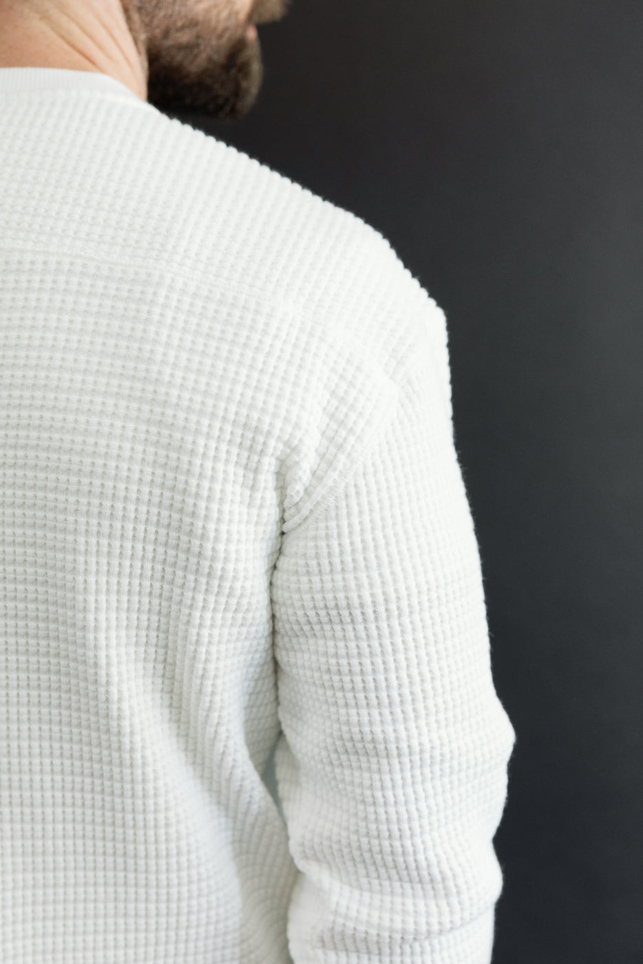 Close-up back view of white waffle knit fabric on a male model, 5'9