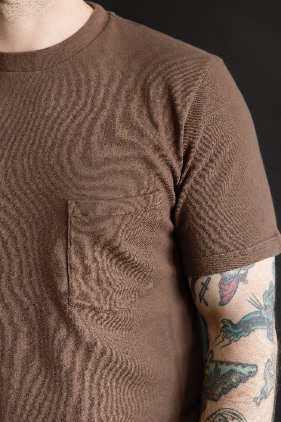 Close-up front view of brown cotton hemp pocket t-shirt on male model, 5'9