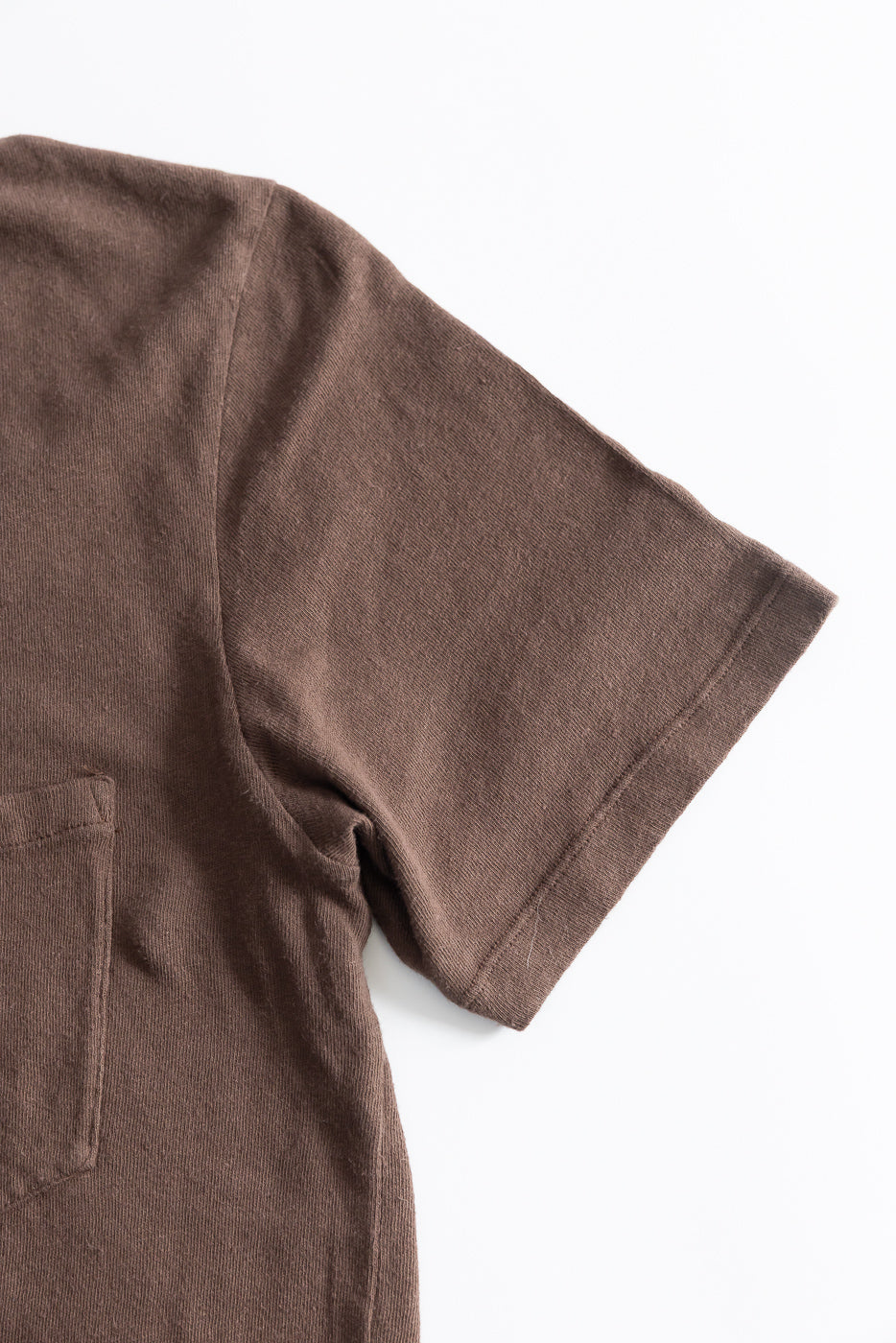 Close-up of front right sleeve, shoulder, and chest pocket of brown cotton hemp t-shirt