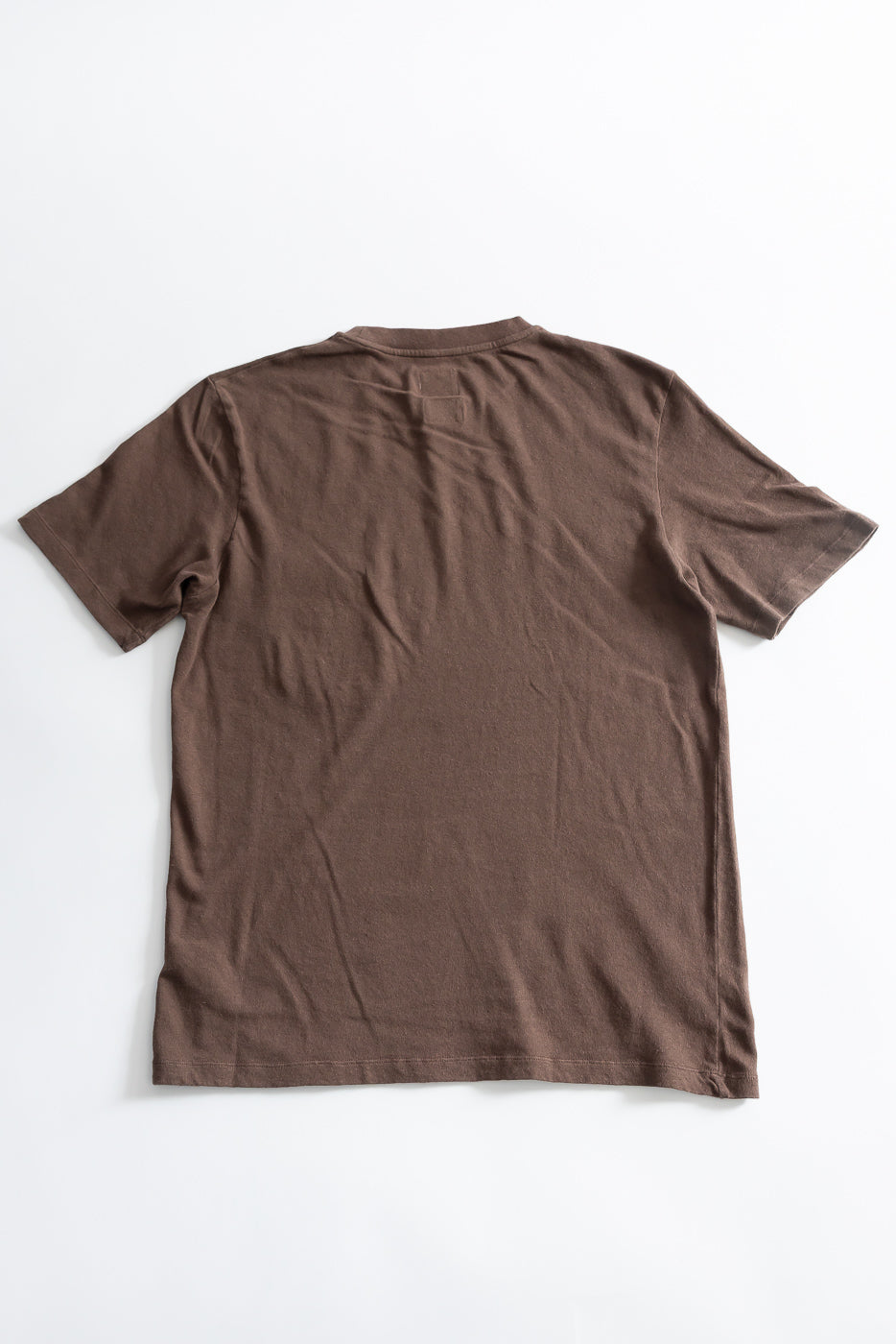Flat lay of brown cotton hemp t-shirt, back view, showing short sleeves and straight hem.