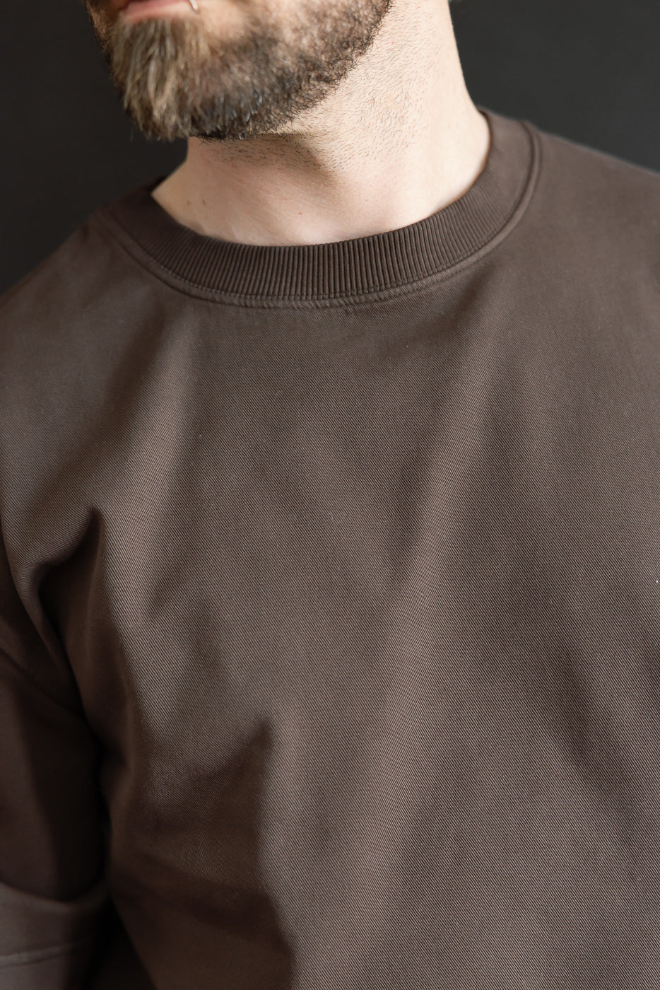 Close-up of front chest and collar of brown twill shirt on male model, 5'9