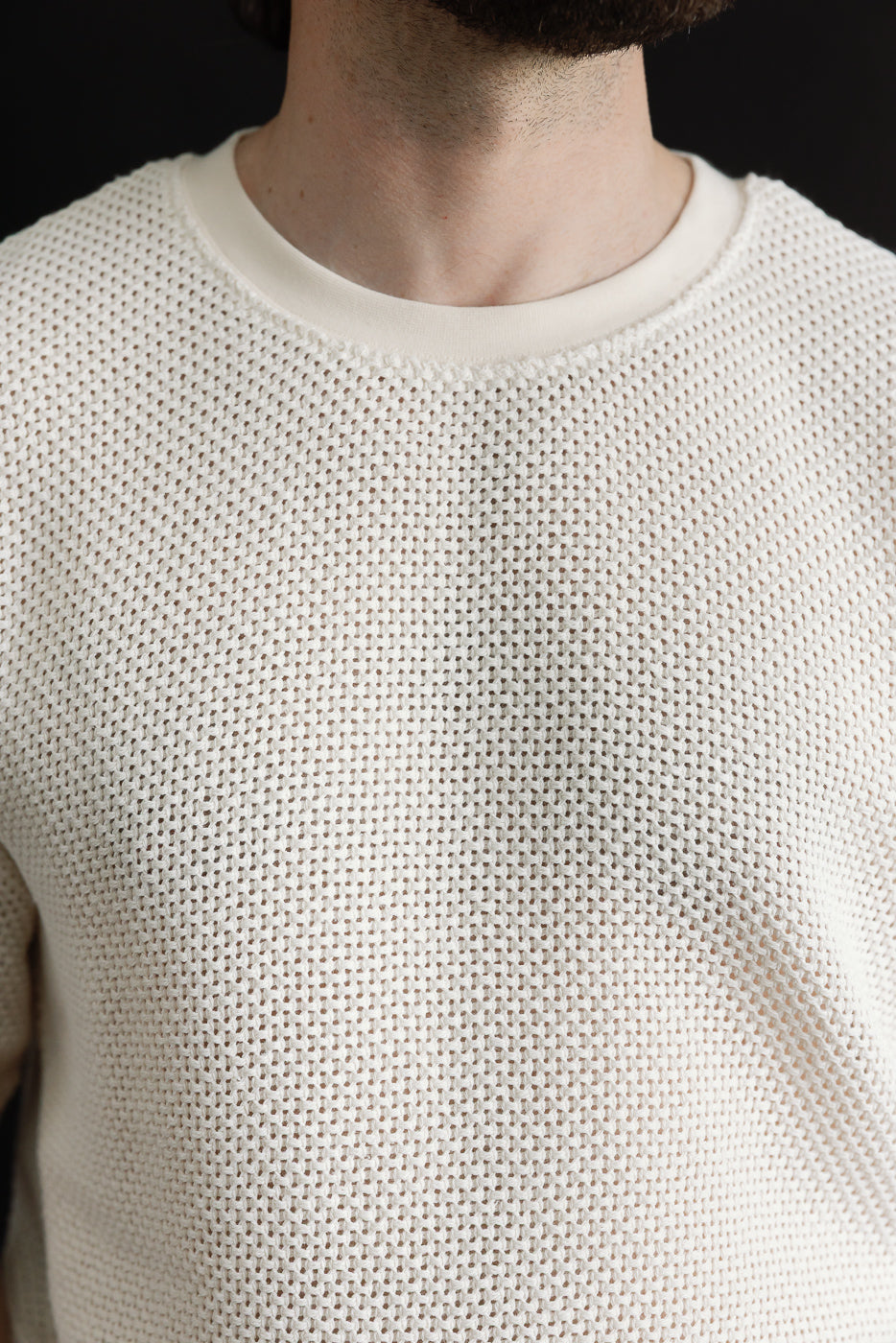 Close-up front detail of cotton ecru t-shirt, male model 5'9