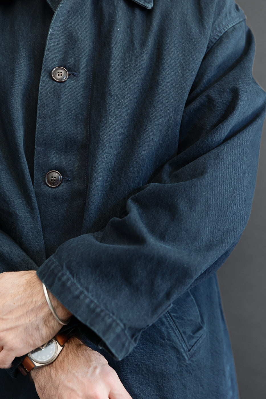 Close-up front view of navy blue chore coat on male model, 5'9