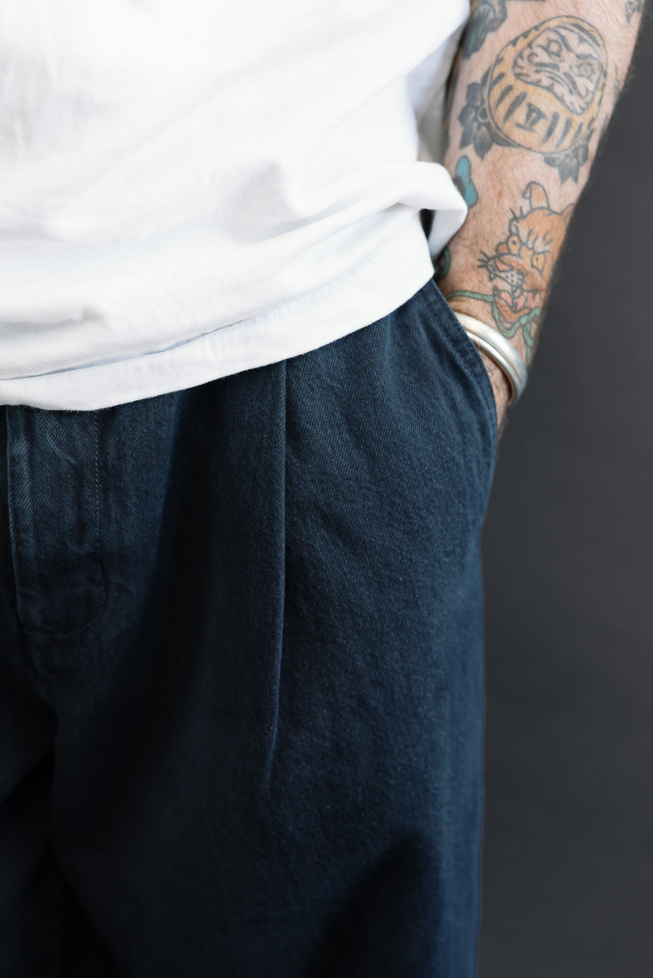 Close-up, side view of dark navy trousers on a male model, 5'9