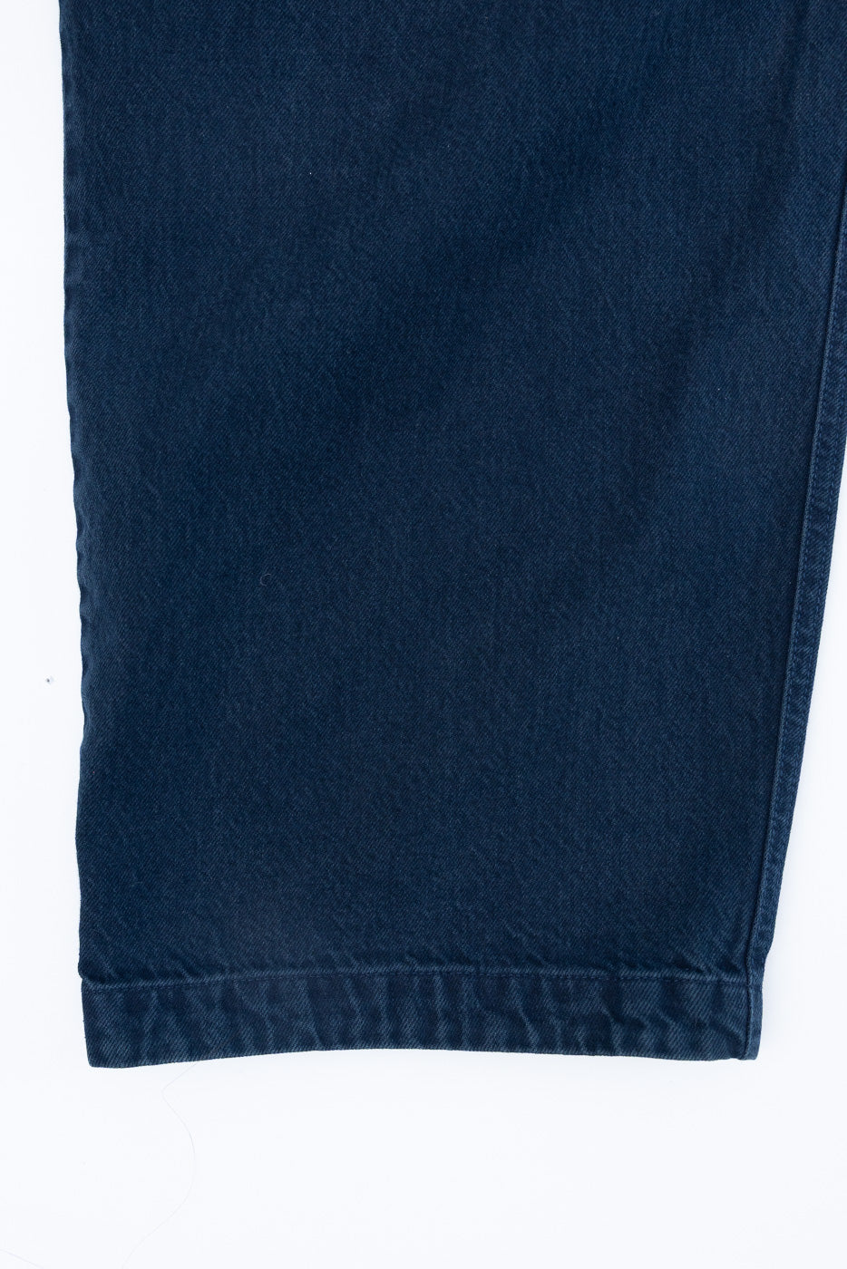 Close-up of the bottom hem of navy blue selvedge denim pants.