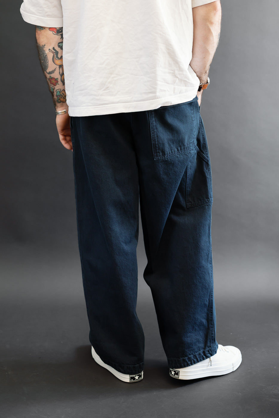 Back view of male model in navy blue wide-leg selvedge trousers.
