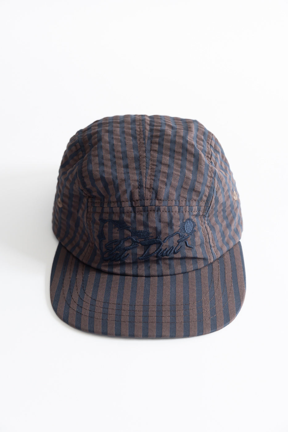 Front close-up of striped navy and brown 5-panel cap, showing brim and embroidered logo detail.