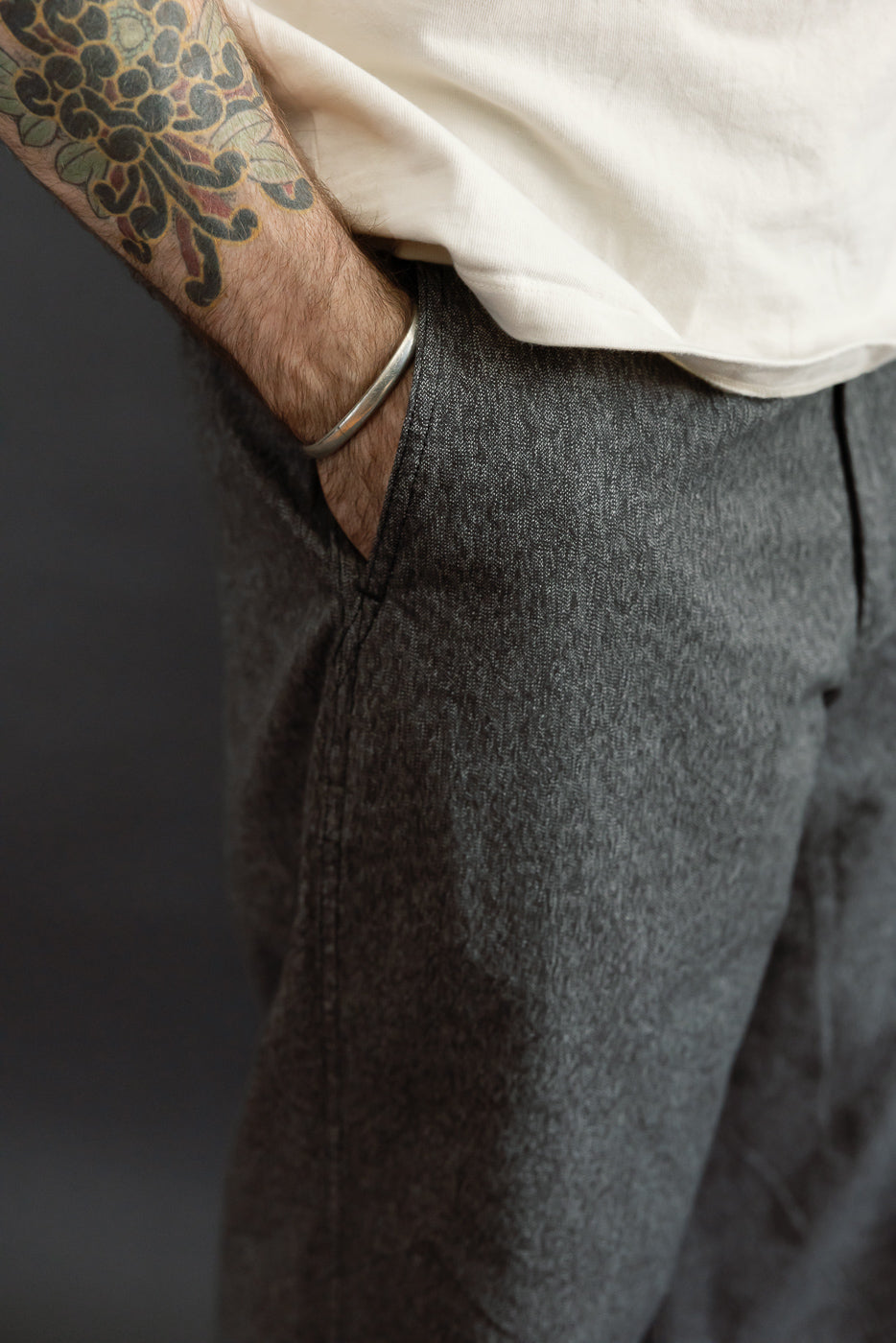 Close-up of male model's side, showing gray selvedge pants texture and fit, 5'9