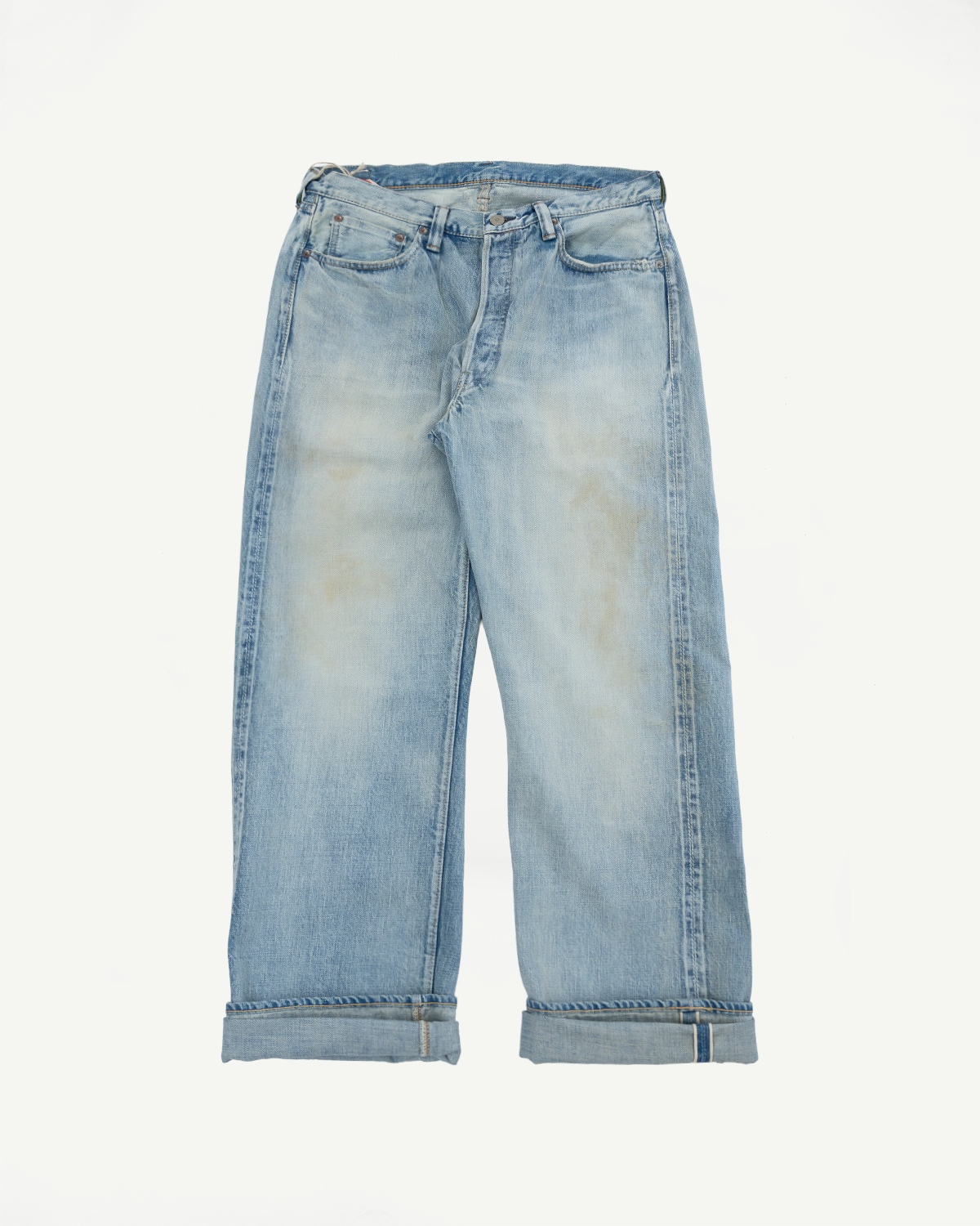 Flat lay front view of light wash wide-leg selvedge jeans with cuffed hems and classic 5-pocket styling