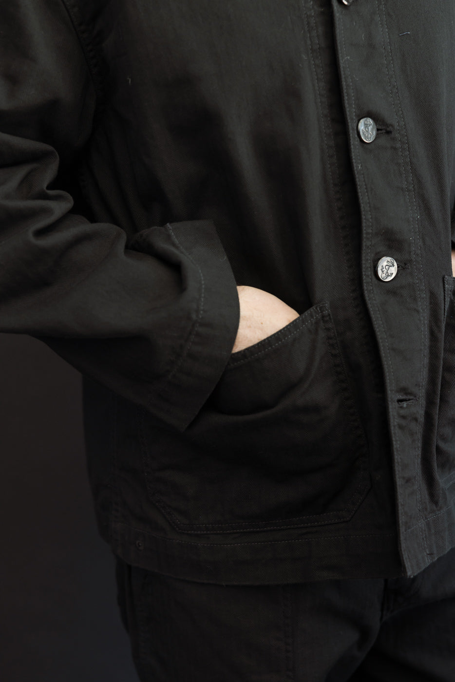 Close-up front view of black work jacket on male model, 5'9