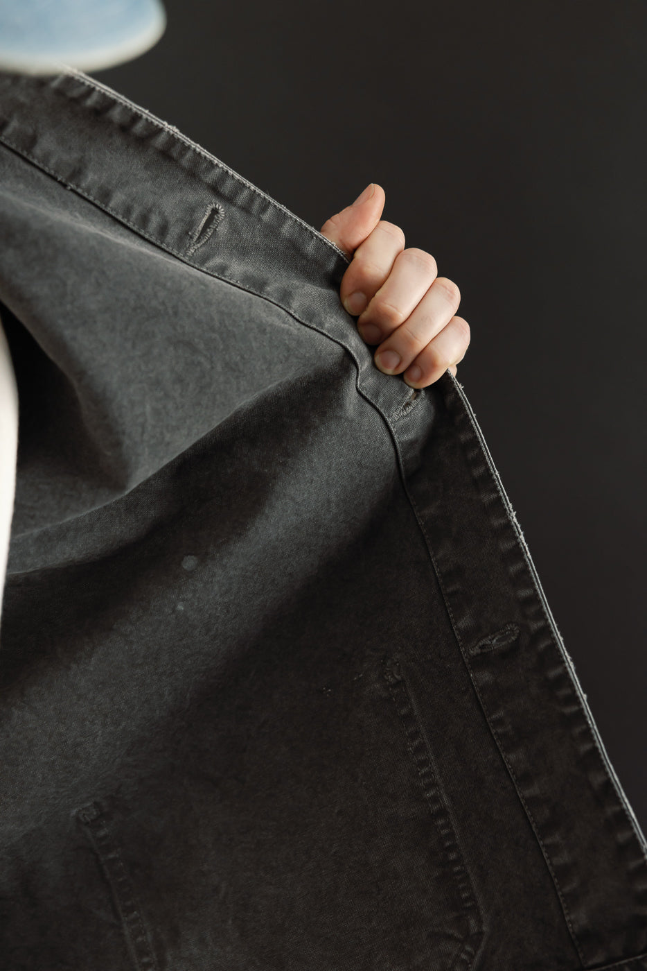 Close-up of dark gray selvedge jeans, front view, showing fabric texture and stitching details