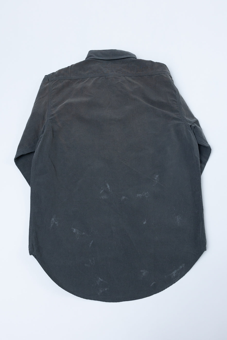 Back view of dark gray shirt with curved hem and subtle texture, flat lay