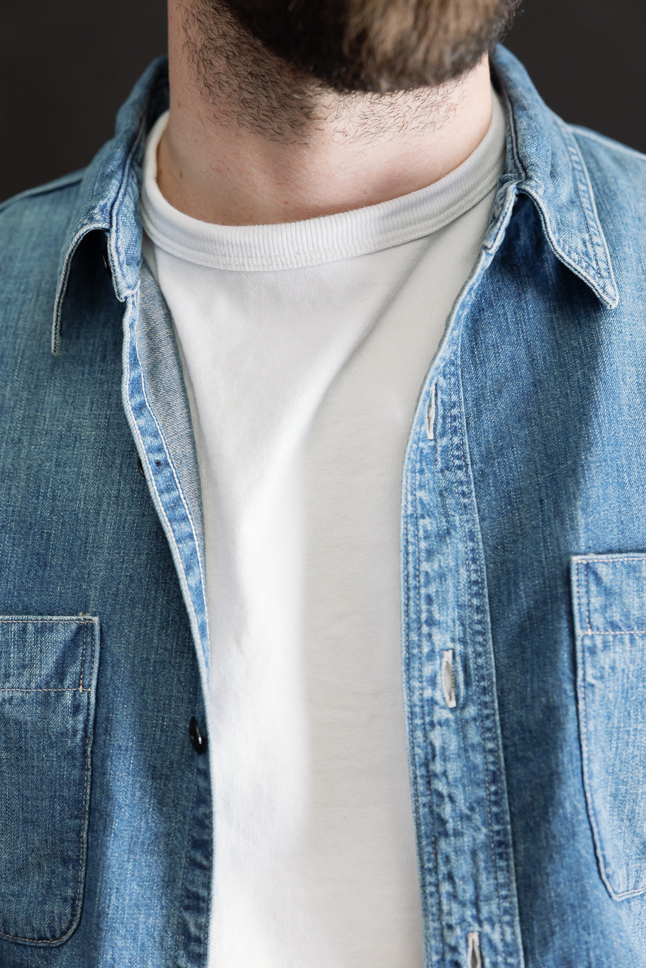 Close-up front of indigo denim work shirt collar and chest, male model 5'9