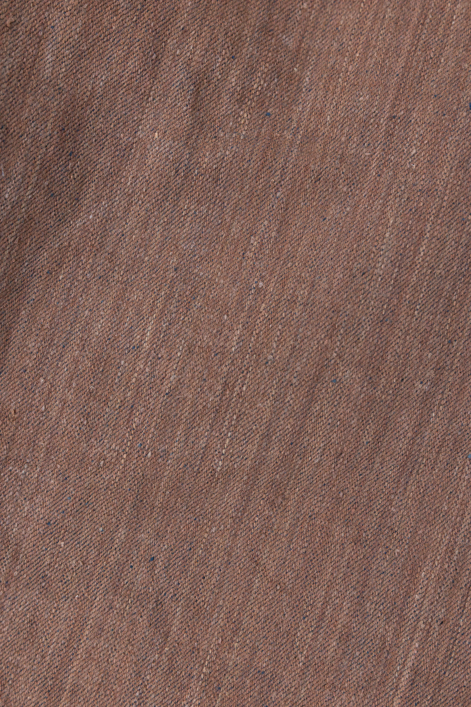 Close-up of brown selvedge denim fabric texture with subtle blue speckles, front view