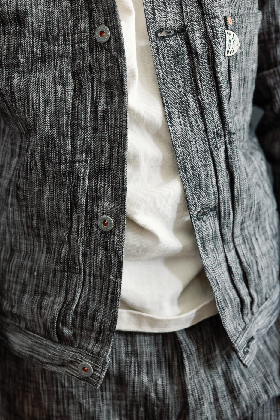 Close-up front view of men's textured gray shirt with button details, worn by 5'9