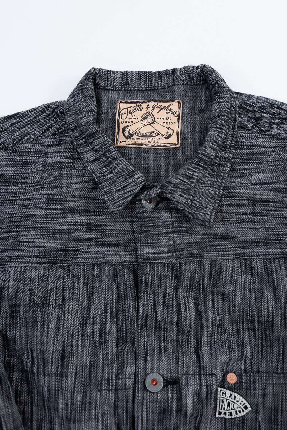 Close-up front view of dark gray textured shirt with collar, buttons, and brand tag details