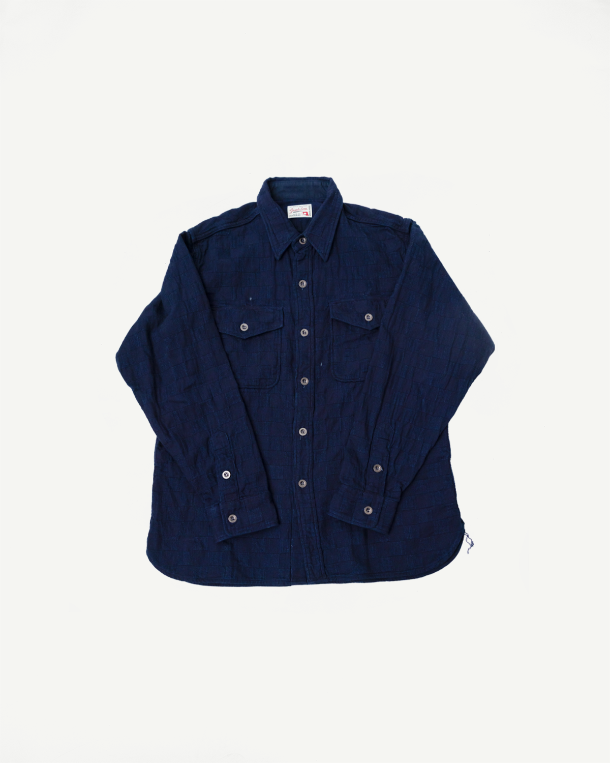 Flat lay front view of indigo jacquard plaid officer shirt with flap pockets and button cuffs