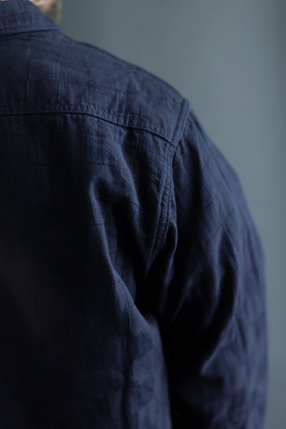 Close-up back view of navy shirt on male model, 5'9
