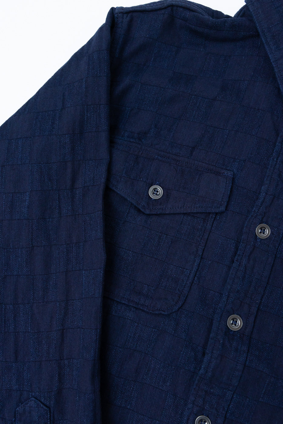 Close-up front view of navy checkered shirt, showing chest pocket, buttons, and fabric texture