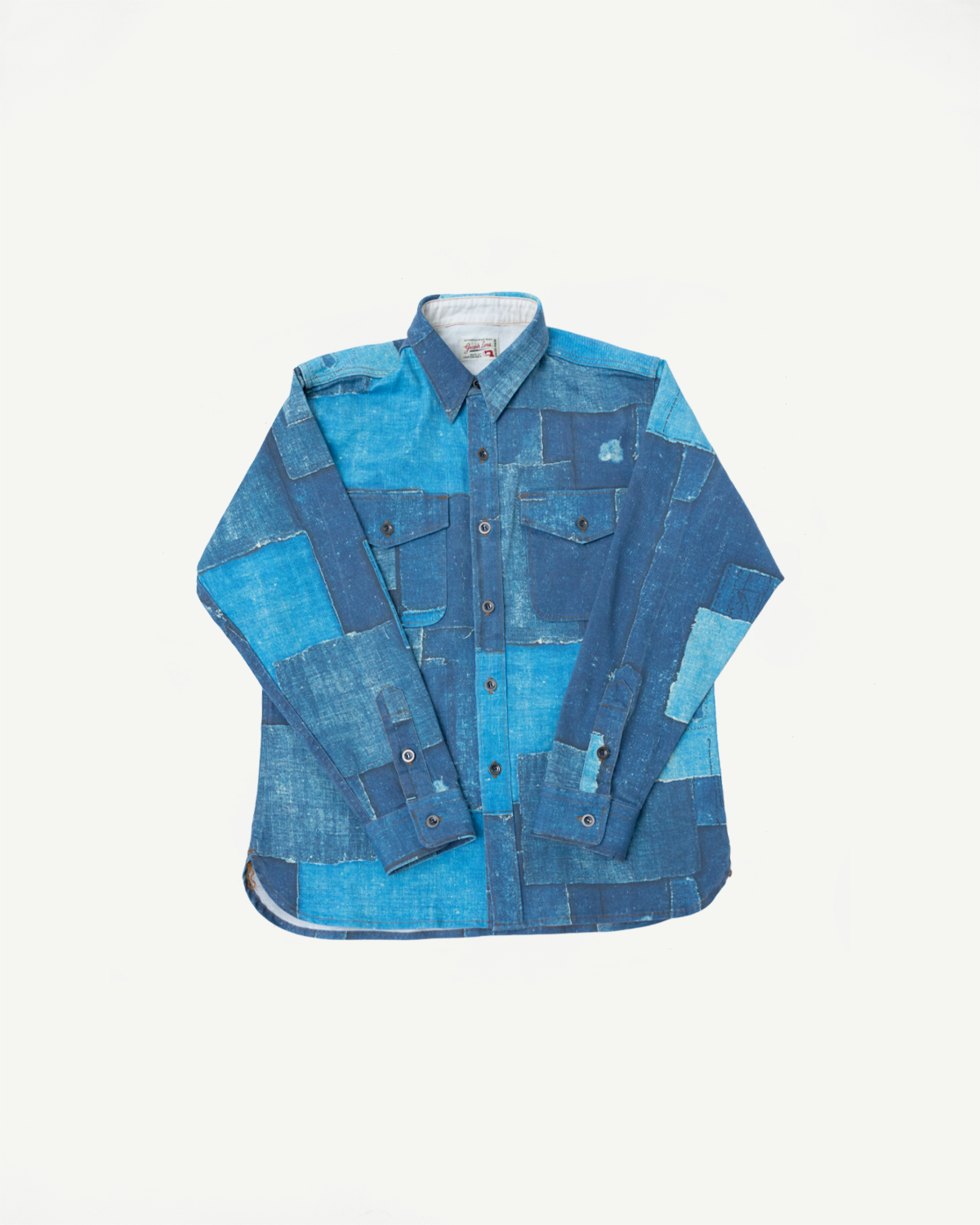 Front flat lay of patchwork denim shirt with button front, chest pockets, and varied blue indigo shades