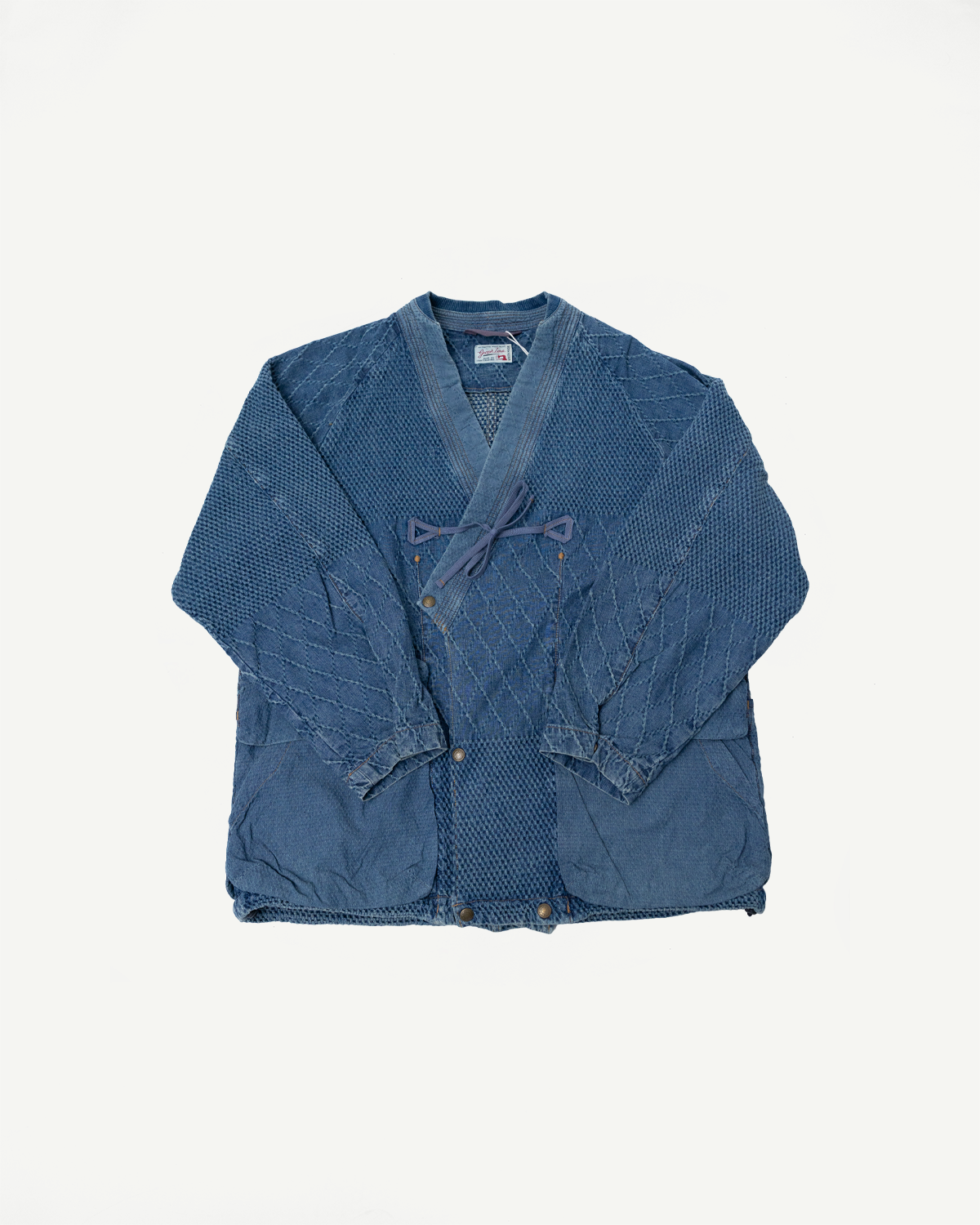 Front flat lay of Graph Zero samue jacket in faded indigo, kimono collar, tie closure, quilted texture