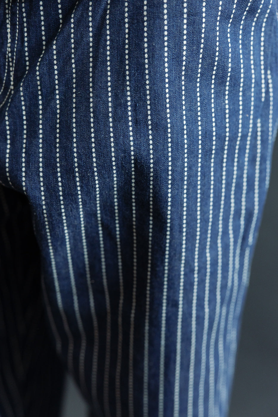 Close-up of front selvedge denim pants with white pinstripes, showcasing fabric texture and weave detail.