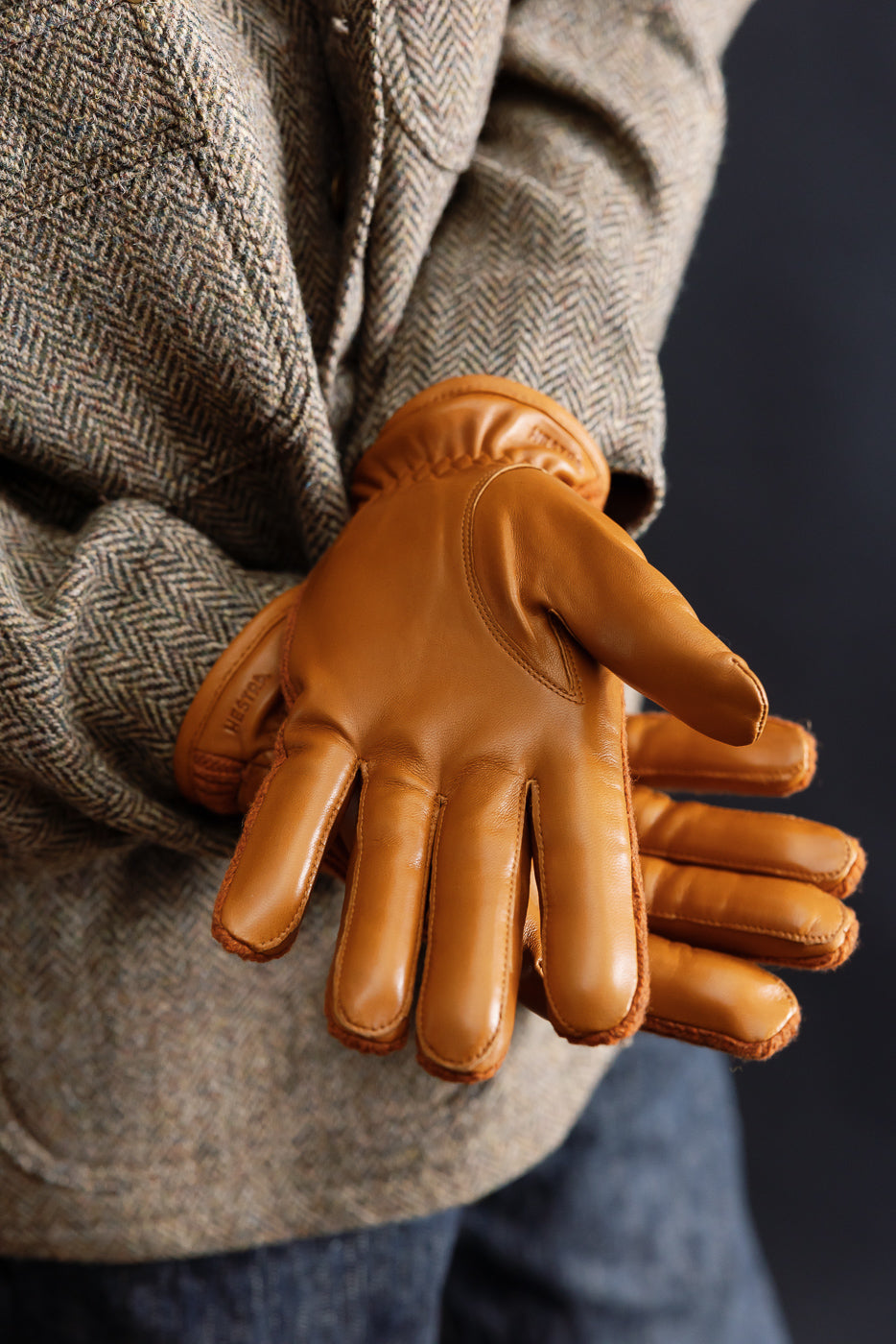 Close-up of Hestra Christopher glove in cork leather, shown on male model’s back, palm view