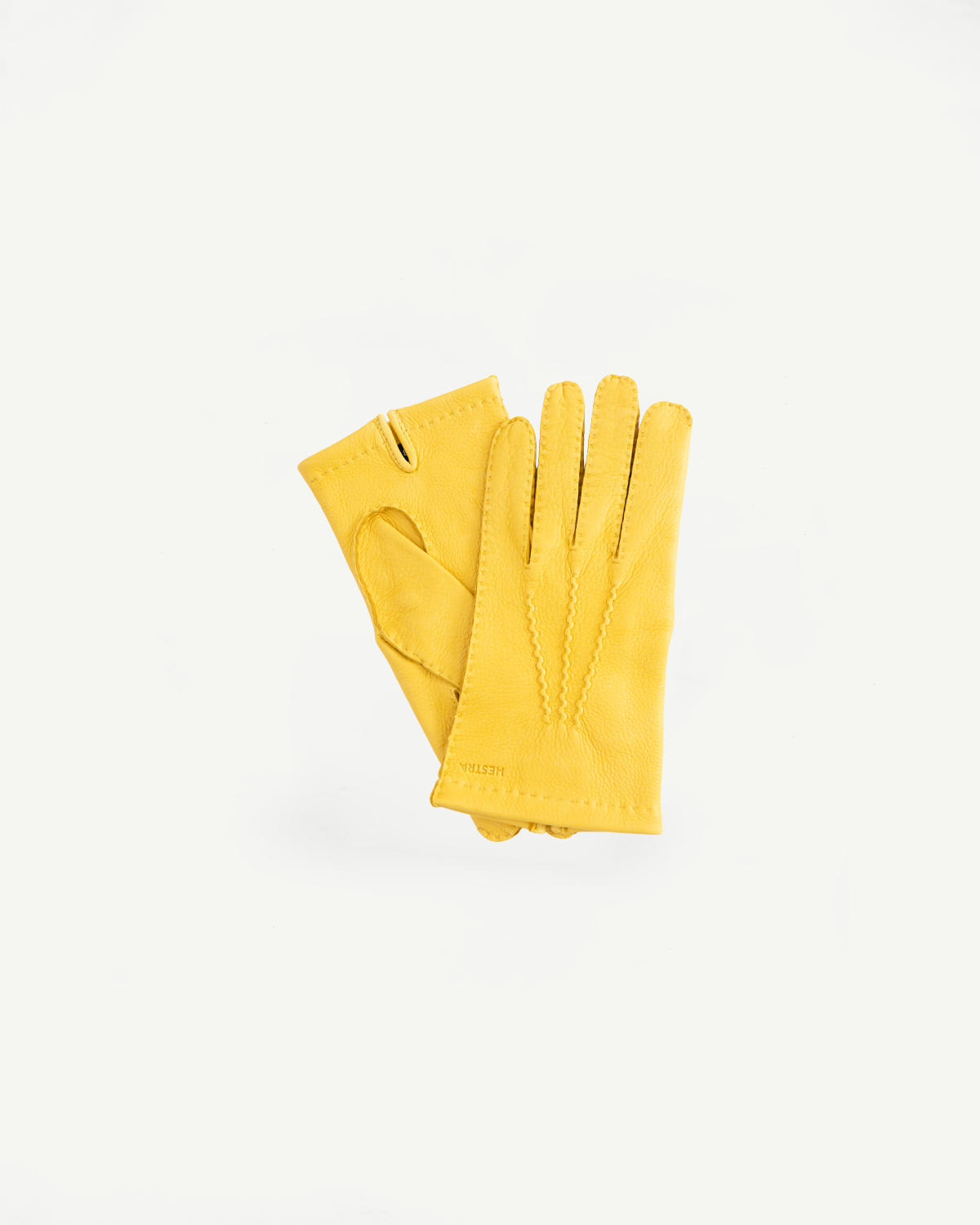 Flat lay front view of Hestra Henry natural yellow leather gloves, stitching details visible.